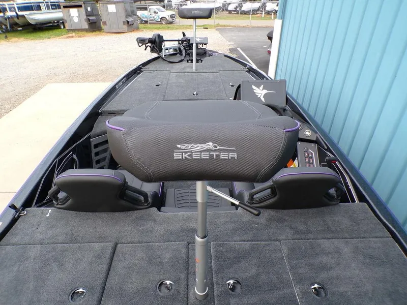 Slide: The Image of 2025 Skeeter ZXR20 boat interior with seating and control panel, docked near a blue building. - 20