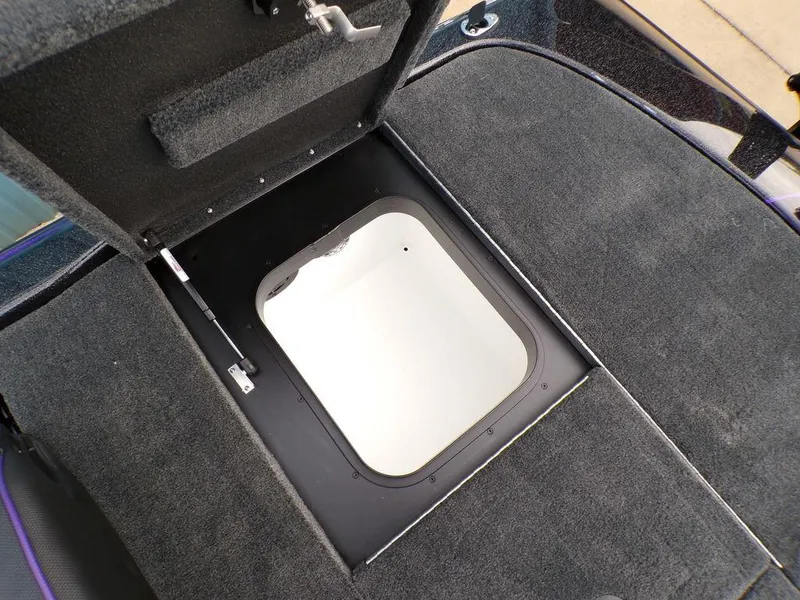 Slide: The Image of 2025 Skeeter ZXR20 boat storage compartment with open hatch, featuring carpeted interior. - 22