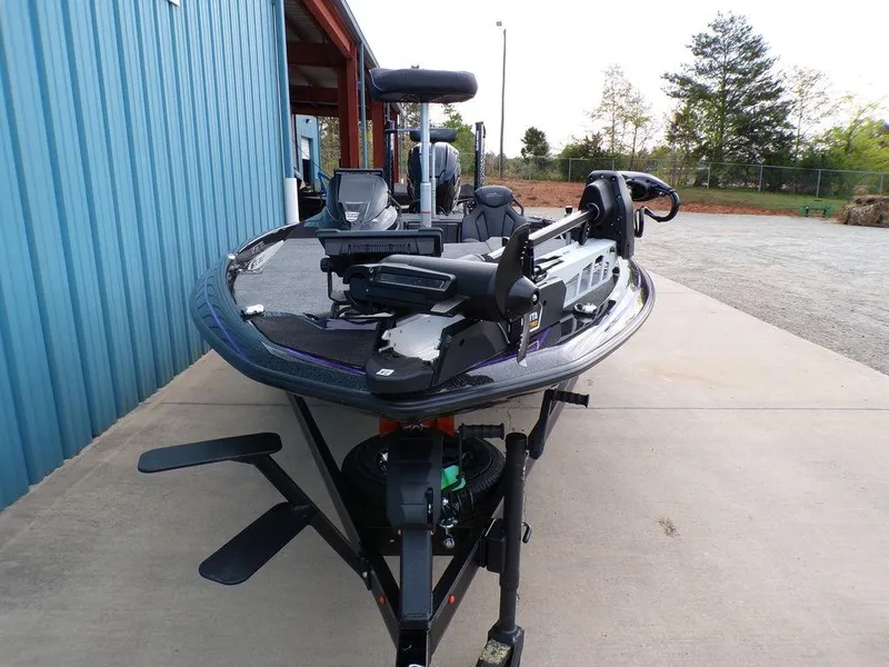 Slide: The Image of 2025 Skeeter ZXR20 fishing boat parked on concrete near blue building. - 7