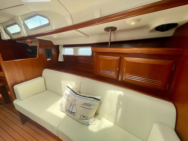 Slide: The Image of Interior of 2004 Beneteau Oceanis Clipper 473 with white seating and wooden cabinetry. - 16