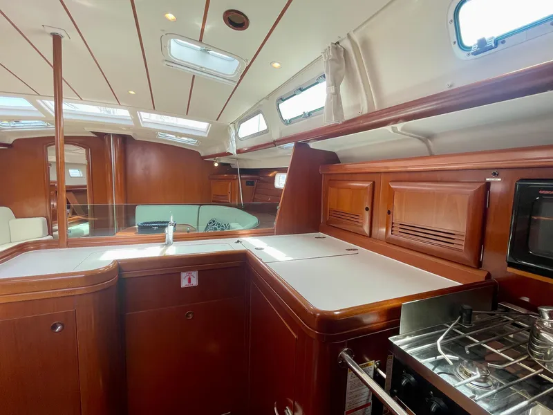 Slide: The Image of Interior of 2004 Beneteau Oceanis Clipper 473 yacht with wooden cabinetry and modern kitchen amenities. - 20
