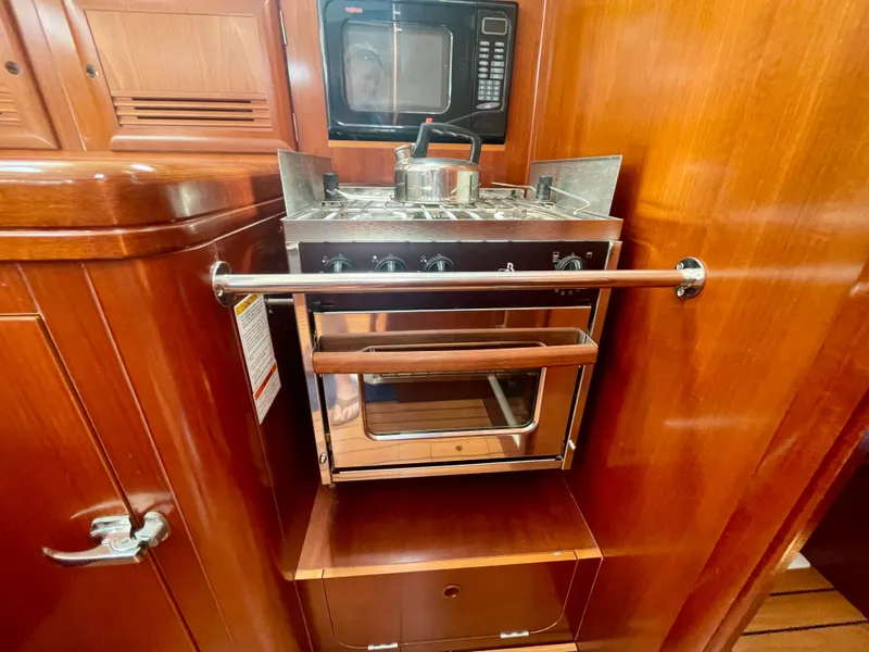 Slide: The Image of Galley kitchen in 2004 Beneteau Oceanis Clipper 473 with stove and microwave. - 25