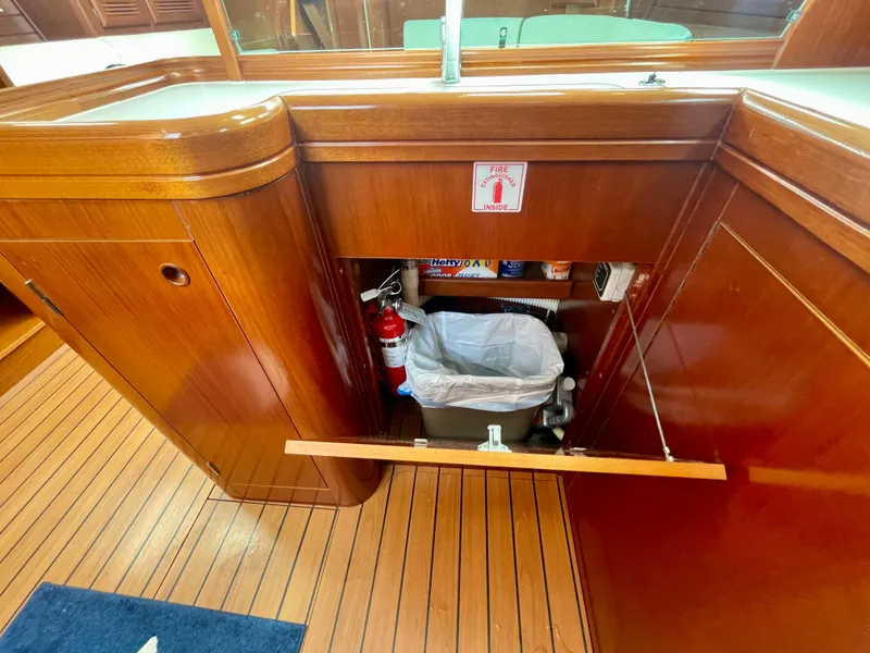 Slide: The Image of 2004 Beneteau Oceanis Clipper 473 yacht interior with wooden cabinetry and storage space. - 27