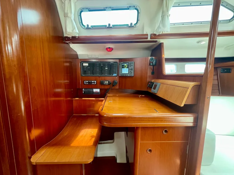 Slide: The Image of 2004 Beneteau Oceanis Clipper 473 interior with wooden navigation station and control panels. - 29