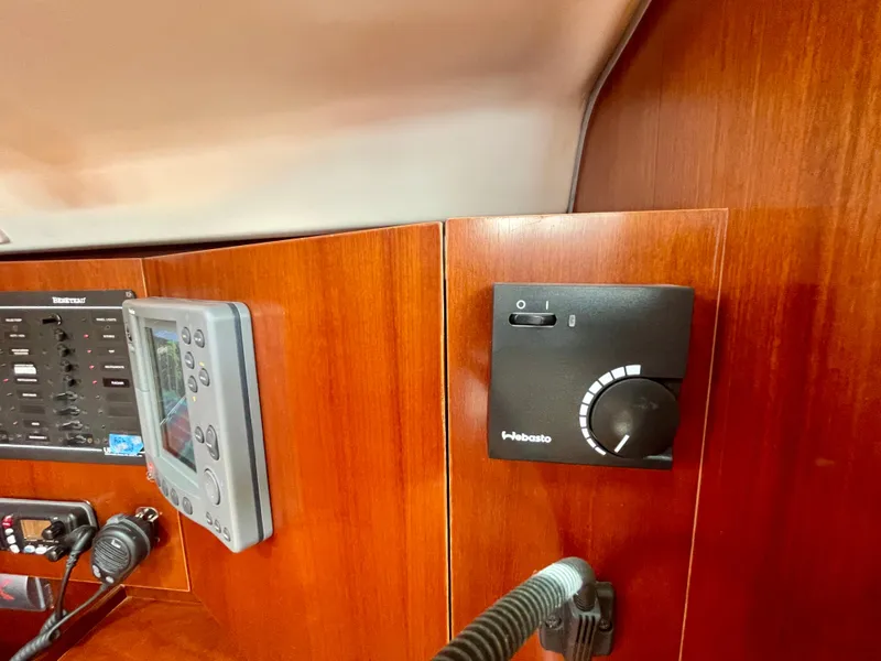 Slide: The Image of Control panel inside 2004 Beneteau Oceanis Clipper 473 yacht, featuring navigation and communication equipment. - 34