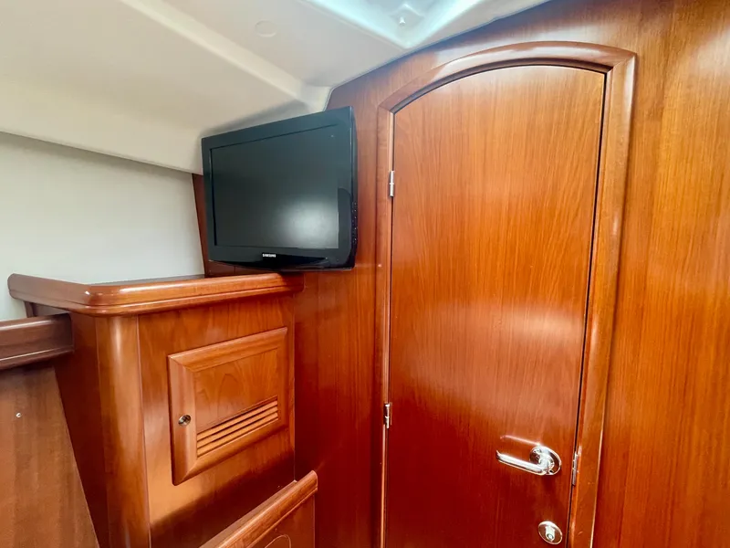 Slide: The Image of Interior of 2004 Beneteau Oceanis Clipper 473 with wooden finish and mounted TV. - 38