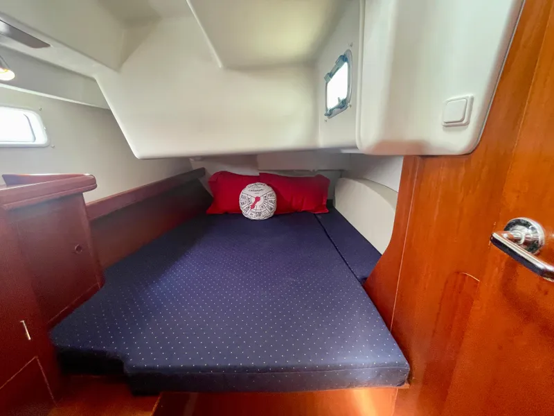 Slide: The Image of Cozy cabin interior of 2004 Beneteau Oceanis Clipper 473 with blue bedding and red pillows. - 45
