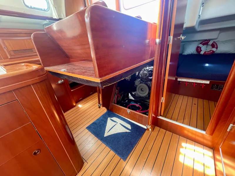 Slide: The Image of Interior of 2004 Beneteau Oceanis Clipper 473 yacht, showcasing engine access and wooden flooring. - 48