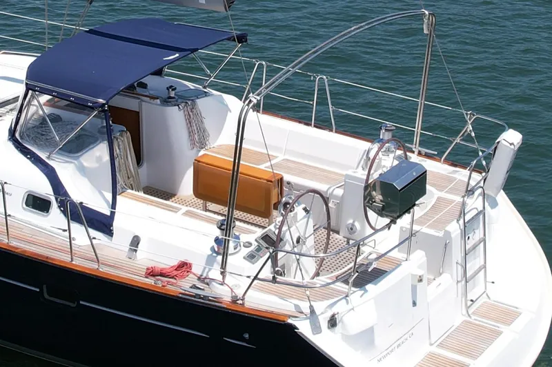 Slide: The Image of 2004 Beneteau Oceanis Clipper 473 sailboat with spacious deck and blue canopy. - 9