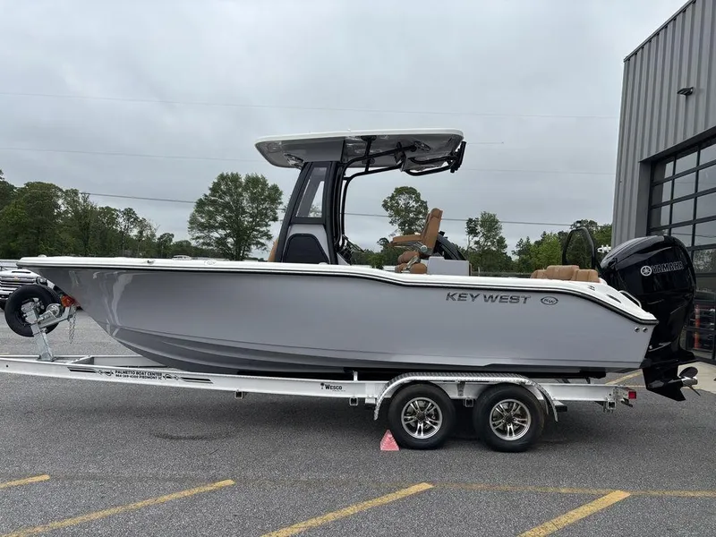 Slide: The Image of 2025 Key West 239FSR boat on trailer, parked outdoors near a building. - 20