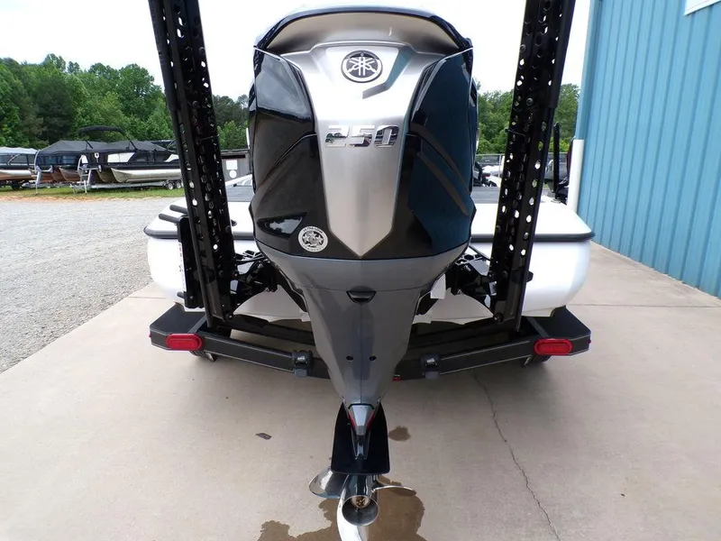 Slide: The Image of 2025 Skeeter ZXR20 boat with powerful outboard motor, parked on concrete near blue building. - 18