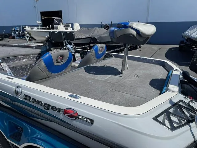 Slide: The Image of 2018 Ranger Z521L boat with blue and gray seating, parked outdoors. - 6