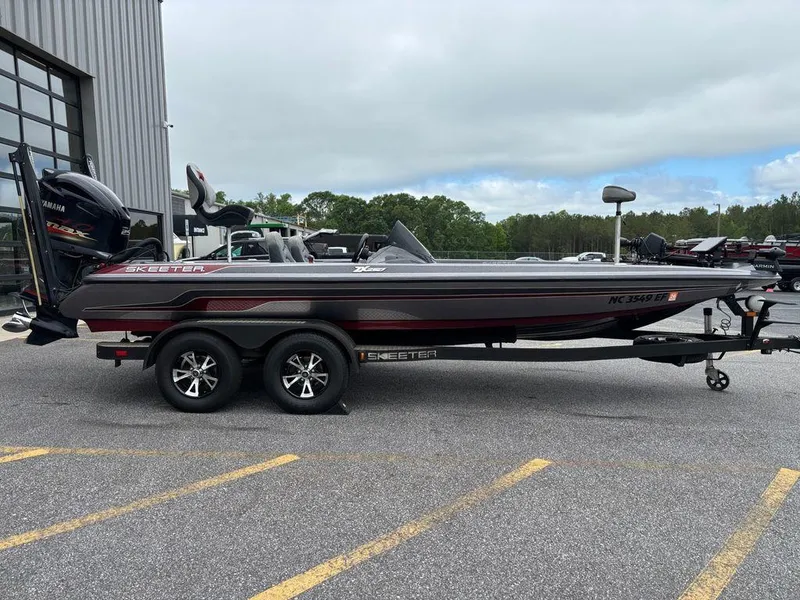 Slide: The Image of 2017 Skeeter ZX250 bass boat on trailer, parked outdoors near a building. - 1