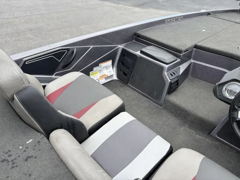 Slide: The Image of 2017 Skeeter ZX250 boat interior with gray and red seating, dashboard, and storage compartments. - 13
