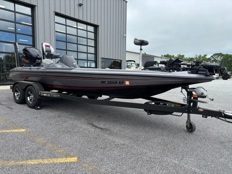 Slide: The Image of 2017 Skeeter ZX250 bass boat on trailer outside a garage. - 2