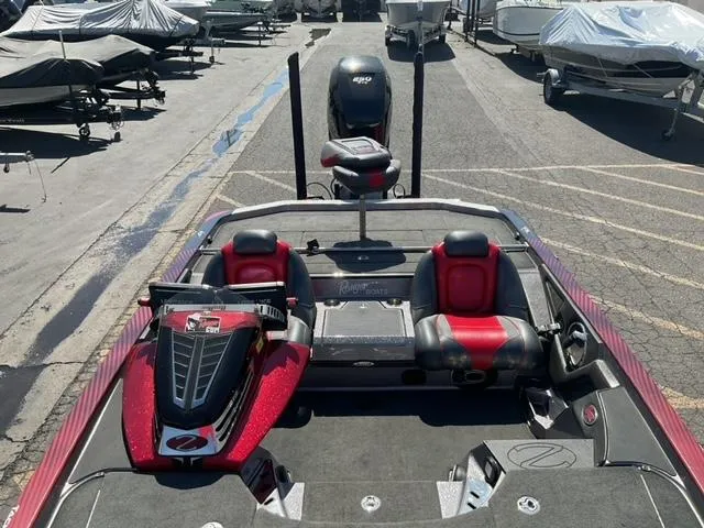 Slide: The Image of 2016 Ranger Z521 Comanche boat with red and black seats, parked in a marina. - 8