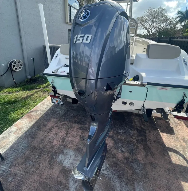 Slide: The Image of 2024 Key West 203 FS boat with Yamaha 150 outboard motor, parked on concrete. - 10