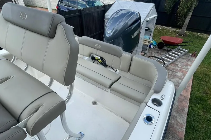 Slide: The Image of 2024 Key West 203 FS boat interior with seating and Yamaha engine in a backyard setting. - 6