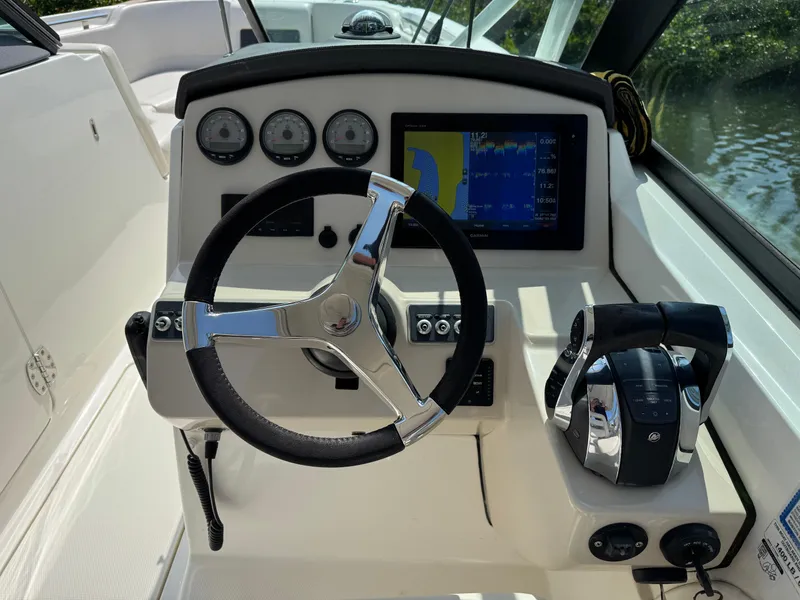 Slide: The Image of 2018 Boston Whaler 270 Vantage helm with steering wheel, gauges, and navigation display. - 14
