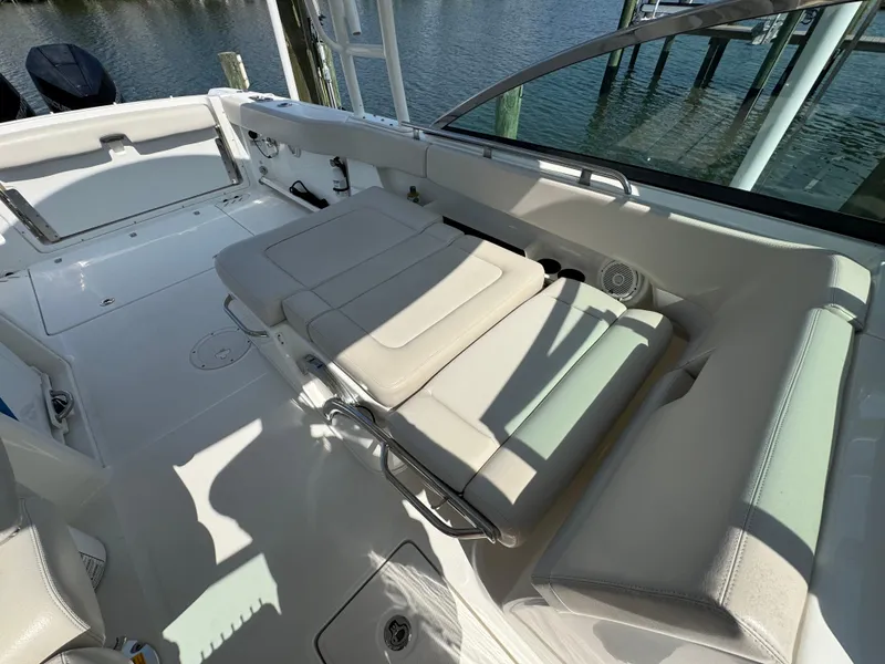 Slide: The Image of 2018 Boston Whaler 270 Vantage boat interior with cushioned seating and water view. - 27
