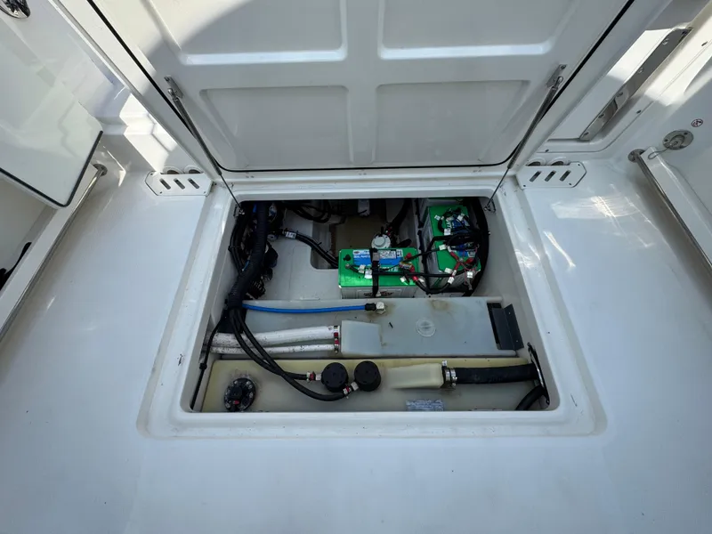Slide: The Image of 2018 Boston Whaler 270 Vantage storage compartment with visible wiring and battery setup. - 32