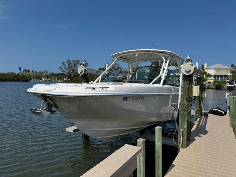 Slide: The Image of 2018 Boston Whaler 270 Vantage boat docked on a sunny day by the water. - 4