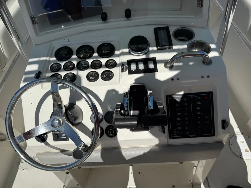 Slide: The Image of 1994 Fountain 31 Tournament Edition boat dashboard with steering wheel and control panel. - 16