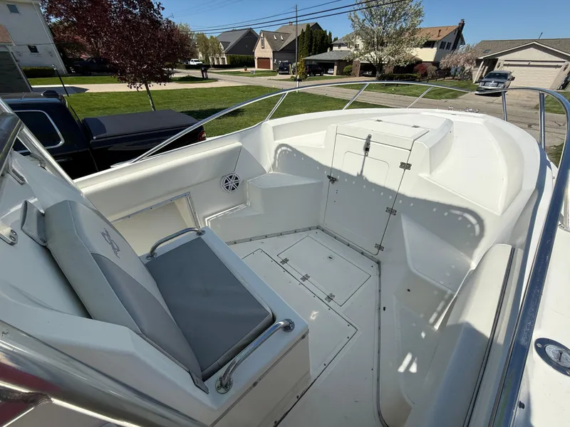 Slide: The Image of 1994 Fountain 31 Tournament Edition boat interior with seating and storage, parked in a residential area. - 19