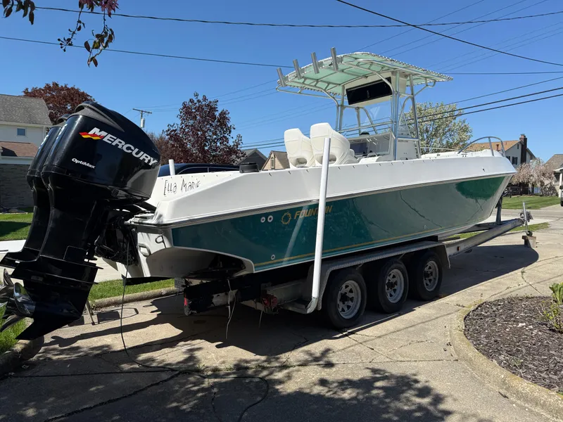 Slide: The Image of 1994 Fountain 31 Tournament Edition boat on trailer with Mercury outboard engine. - 2