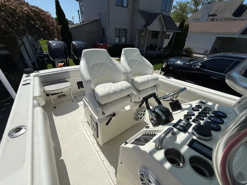 Slide: The Image of 1994 Fountain 31 Tournament Edition boat interior with dual white captain chairs and control panel. - 24