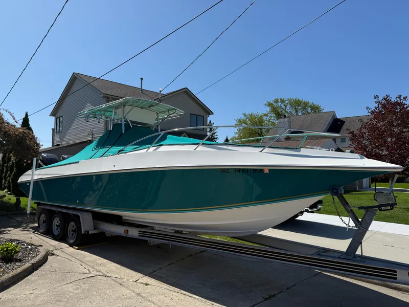 Slide: The Image of 1994 Fountain 31 Tournament Edition boat on trailer, parked in residential driveway. - 29