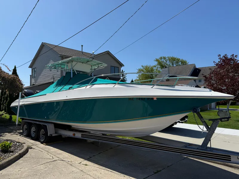 Slide: The Image of 1994 Fountain 31 Tournament Edition boat on trailer, parked in residential driveway. - 30