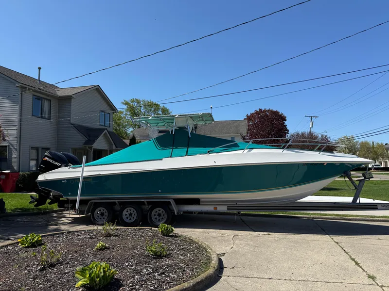 Slide: The Image of 1994 Fountain 31 Tournament Edition boat on trailer in residential driveway. - 31