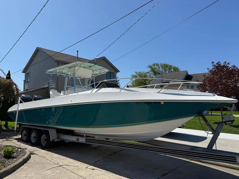 Slide: The Image of 1994 Fountain 31 Tournament Edition boat on trailer, parked in residential driveway. - 5