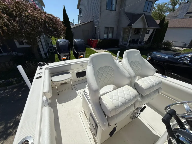 Slide: The Image of 1994 Fountain 31 Tournament Edition boat with white seating, dual engines, and residential background. - 7
