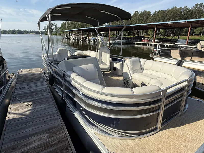 Slide: The Image of 2019 Crestliner 220 Rally DX Center Walk-through pontoon boat docked on a serene lake. - 3