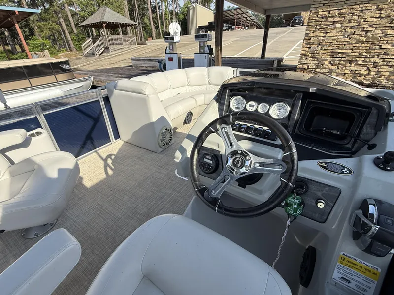 Slide: The Image of 2019 Crestliner 220 Rally DX Center Walk-through boat interior with steering wheel and seating. - 5