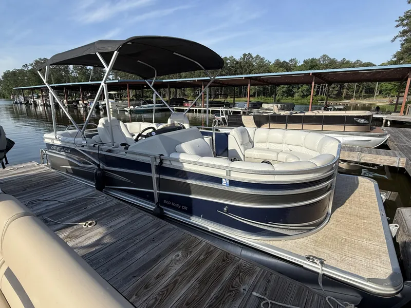 Slide: The Image of 2019 Crestliner 220 Rally DX Center Walk-through pontoon boat docked on a sunny day. - 9