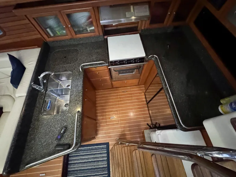 Slide: The Image of 2009 Hunter 50 Center Cockpit kitchen with granite countertops and wooden cabinetry. - 15