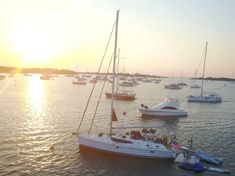 Slide: The Image of Sailboats anchored at sunset, featuring a 2009 Hunter 50 Center Cockpit. - 2