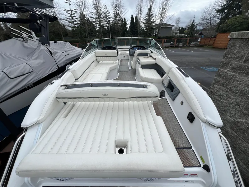 Slide: The Image of 2017 Cobalt A28 boat with spacious white seating and sleek design in a parking area. - 10