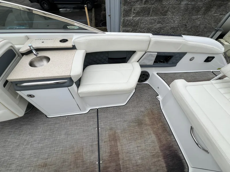 Slide: The Image of 2017 Cobalt A28 boat interior with white seating, sink, and storage area. - 14