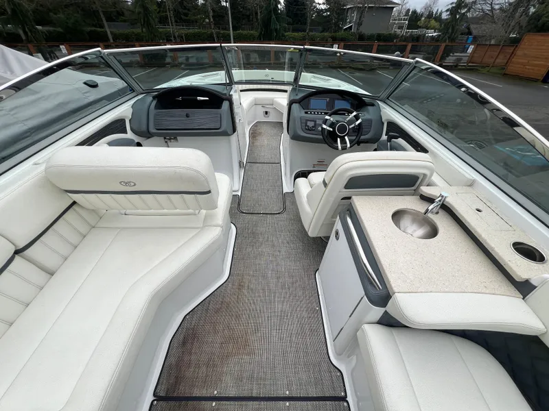 Slide: The Image of 2017 Cobalt A28 boat interior with white seating, steering wheel, and sink. - 15