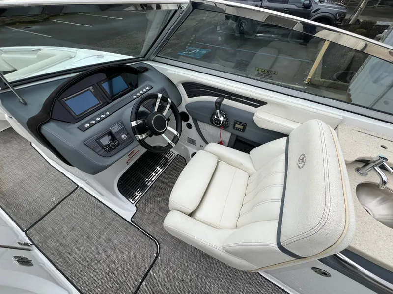 Slide: The Image of 2017 Cobalt A28 boat cockpit with steering wheel, dashboard, and white captain's chair. - 20