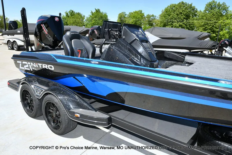 Slide: The Image of 2024 Nitro Z21 XL Pro Pack boat with sleek design and dual-axle trailer. - 15