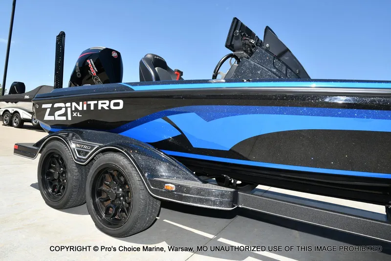 Slide: The Image of 2024 Nitro Z21 XL Pro Pack boat with blue and black design on trailer. - 16