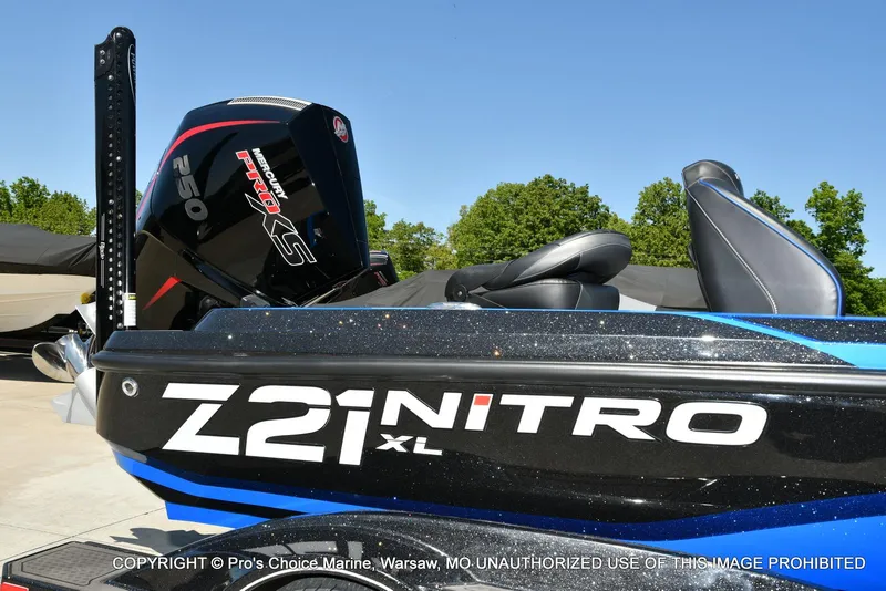 Slide: The Image of 2024 Nitro Z21 XL Pro Pack boat with Mercury Pro XS engine, parked outdoors. - 2