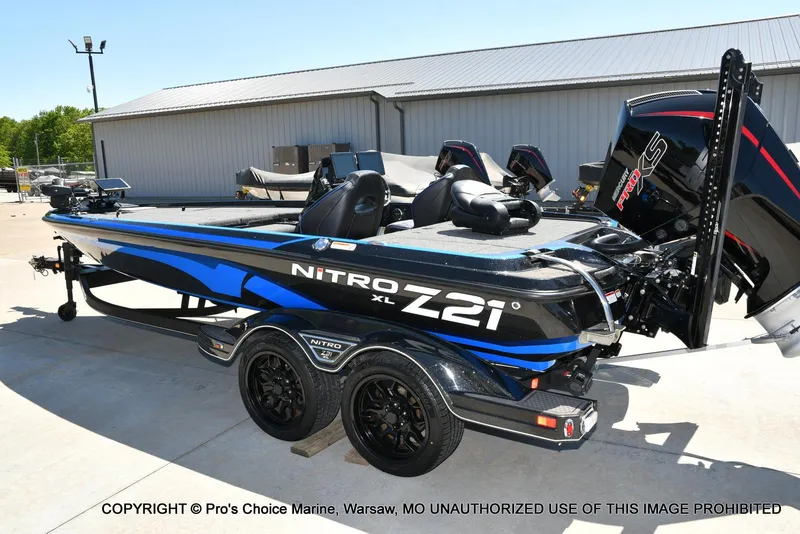 Slide: The Image of 2024 Nitro Z21 XL Pro Pack boat with sleek design and powerful engine, parked outdoors. - 24