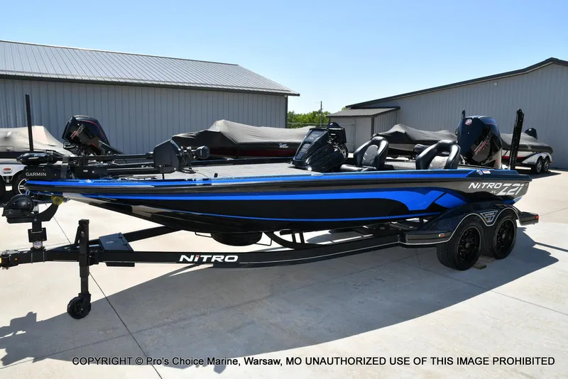 Slide: The Image of 2024 Nitro Z21 XL Pro Pack boat in blue, parked on a trailer in a marina. - 25