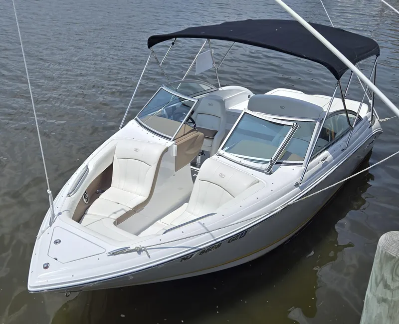 The Image of 2011 Cobalt 222 boat with canopy docked on calm water. - 0